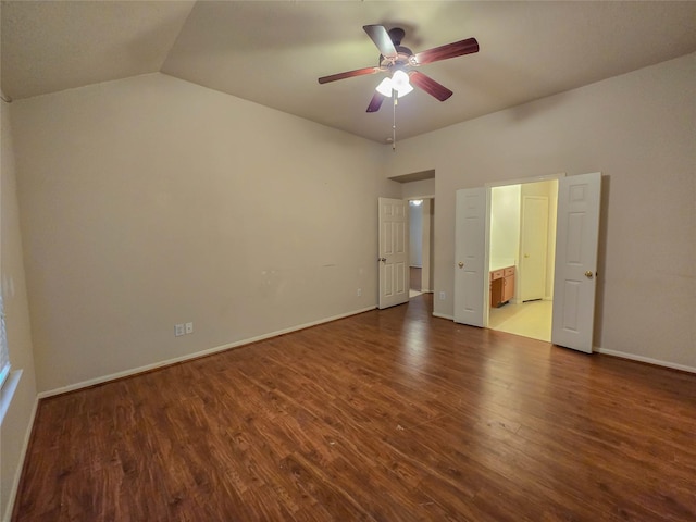 unfurnished bedroom with lofted ceiling, wood finished floors, ensuite bath, ceiling fan, and baseboards