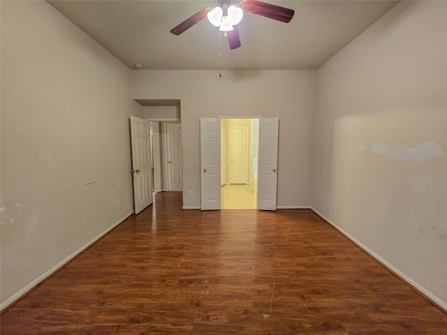 unfurnished bedroom with ceiling fan, baseboards, and dark wood finished floors