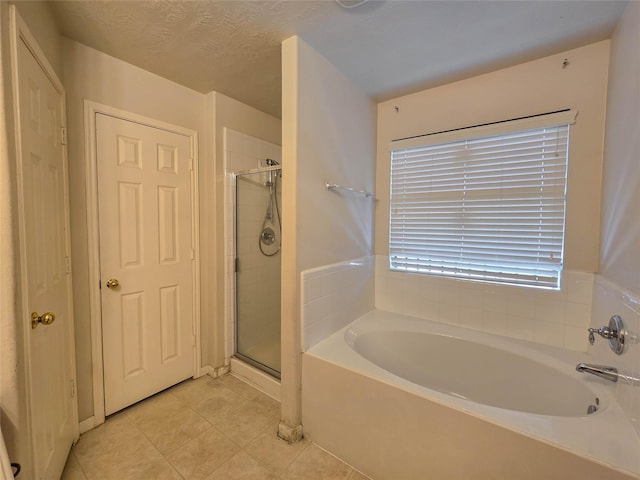 full bathroom with a shower stall, tile patterned flooring, and a garden tub