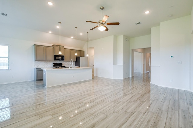 7634 Wrightwood Dr, Pasadena, TX 77505 - kitchen featuring freestanding refrigerator, black microwave, open floor plan, a ceiling fan, and gas range oven