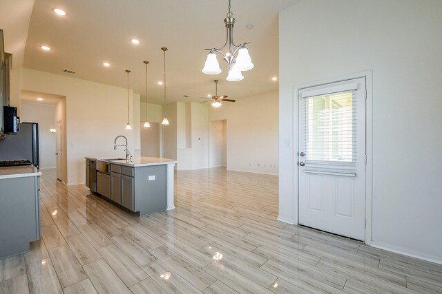 7634 Wrightwood Dr, Pasadena, TX 77505 - kitchen featuring light wood finished floors, light countertops, stainless steel appliances, and gray cabinets