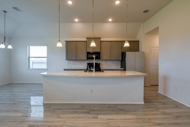 7634 Wrightwood Dr, Pasadena, TX 77505 - kitchen with freestanding refrigerator, black microwave, visible vents, and lofted ceiling