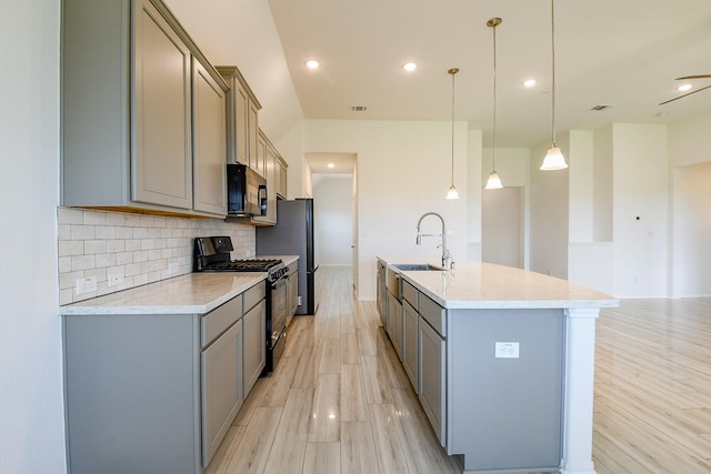 7634 Wrightwood Dr, Pasadena, TX 77505 - kitchen with a sink, gray cabinetry, black appliances, and tasteful backsplash