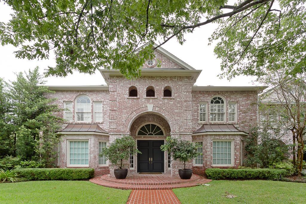 view of front facade with a standing seam roof, brick siding, and a front yard
