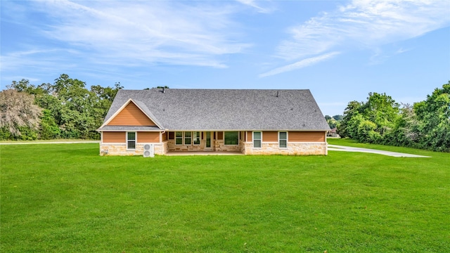 215 Carey Dr, Brenham, TX 77833 - back of property with a yard, stone siding, and a patio