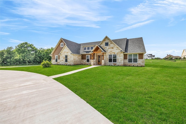 215 Carey Dr, Brenham, TX 77833 - view of front facade with stone siding, a shingled roof, and a front yard