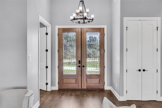 215 Carey Dr, Brenham, TX 77833 - entrance foyer featuring a notable chandelier, french doors, baseboards, and wood finished floors