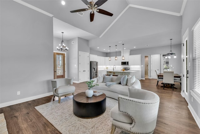 215 Carey Dr, Brenham, TX 77833 - living area with dark wood-style flooring, ceiling fan with notable chandelier, and baseboards