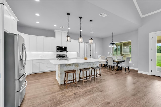 215 Carey Dr, Brenham, TX 77833 - kitchen with light countertops, recessed lighting, visible vents, a center island with sink, and stainless steel appliances