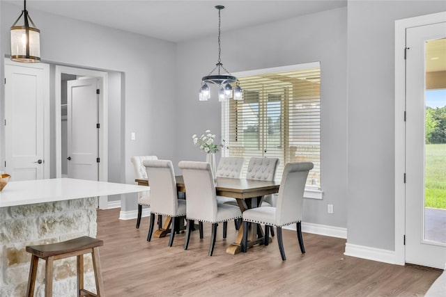 215 Carey Dr, Brenham, TX 77833 - dining room featuring a chandelier, baseboards, and light wood-type flooring
