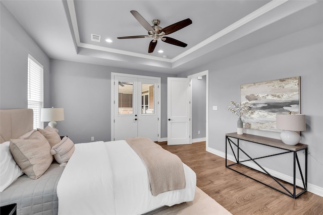 215 Carey Dr, Brenham, TX 77833 - bedroom featuring wood finished floors, a tray ceiling, visible vents, baseboards, and recessed lighting