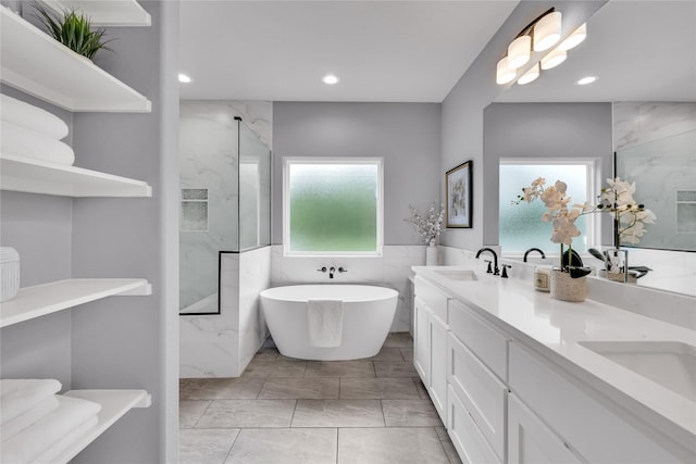 215 Carey Dr, Brenham, TX 77833 - bathroom with a marble finish shower, a sink, a soaking tub, marble finish floor, and recessed lighting