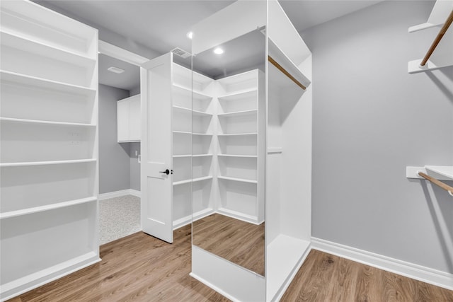 215 Carey Dr, Brenham, TX 77833 - walk in closet with visible vents and wood finished floors