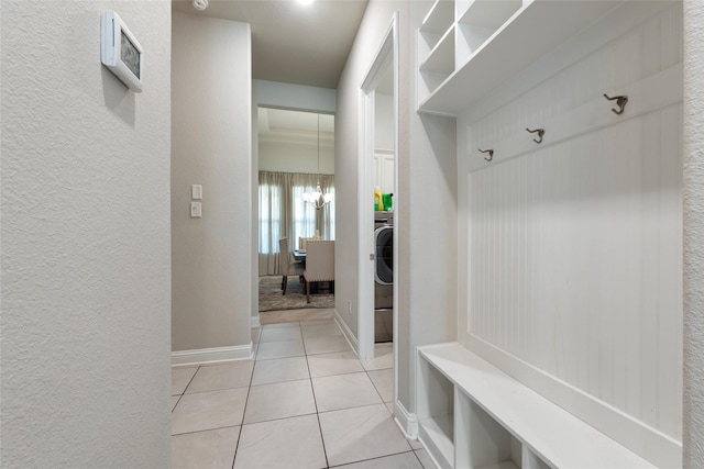 1806 Bridge Gate Ln, Katy, TX 77494 - mudroom with an inviting chandelier, light tile patterned floors, baseboards, a textured wall, and washer / clothes dryer