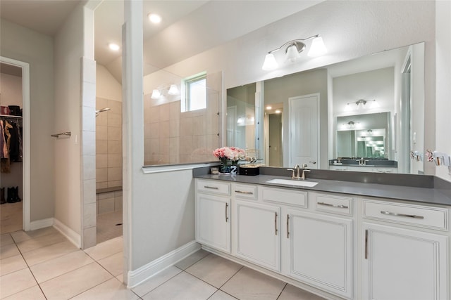 1806 Bridge Gate Ln, Katy, TX 77494 - bathroom featuring vanity, a walk in shower, a spacious closet, and tile patterned floors