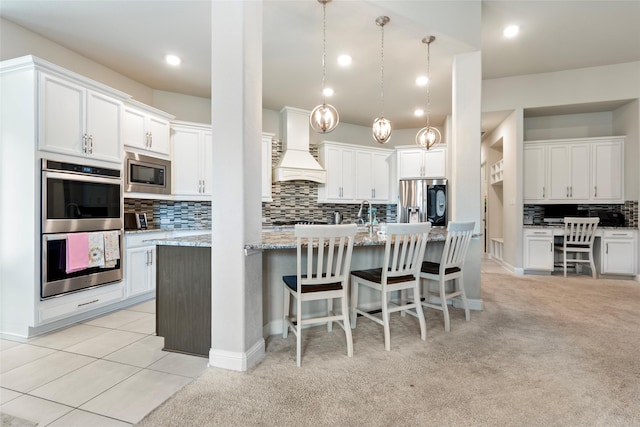 1806 Bridge Gate Ln, Katy, TX 77494 - kitchen with premium range hood, stainless steel appliances, a center island with sink, decorative backsplash, and a kitchen bar