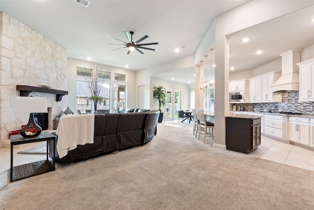 1806 Bridge Gate Ln, Katy, TX 77494 - living area featuring light tile patterned floors, a ceiling fan, a fireplace, light colored carpet, and recessed lighting