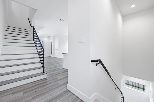 3313 Baer St, Houston, TX 77020 - stairway with baseboards, wood finished floors, and recessed lighting