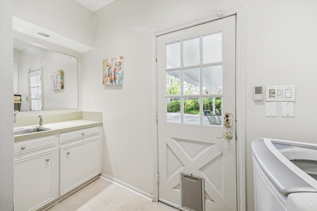 2002 Anvil Dr, Houston, TX 77090 - laundry room with cabinet space, light tile patterned floors, baseboards, and washer and clothes dryer
