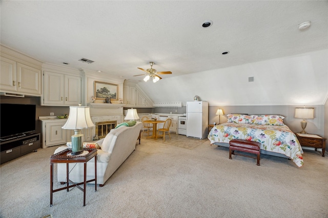 2002 Anvil Dr, Houston, TX 77090 - bedroom with freestanding refrigerator, light colored carpet, vaulted ceiling, and a glass covered fireplace