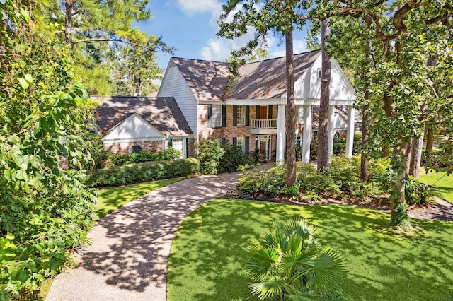 2002 Anvil Dr, Houston, TX 77090 - view of front facade with a balcony, brick siding, and a front yard