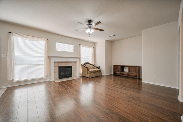 2107 Auburn Vale St, Katy, TX 77493 - unfurnished living room featuring dark wood finished floors, baseboards, a fireplace, and a ceiling fan