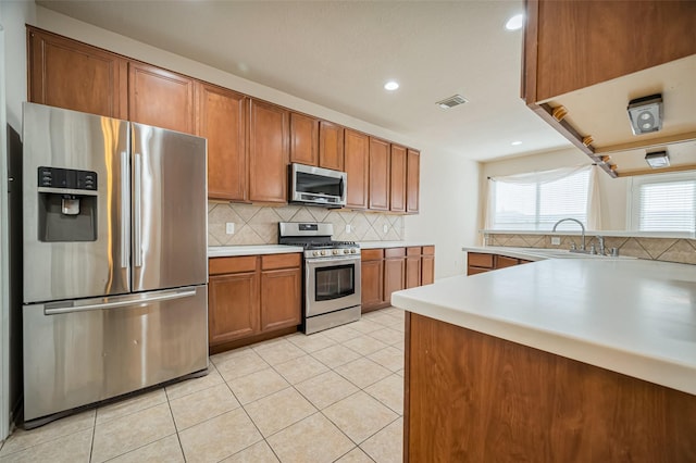 2107 Auburn Vale St, Katy, TX 77493 - kitchen featuring a sink, brown cabinetry, stainless steel appliances, visible vents, and light tile patterned floors