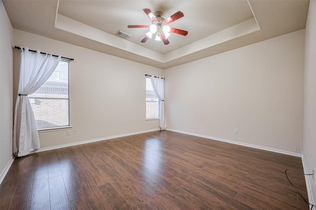 2107 Auburn Vale St, Katy, TX 77493 - empty room featuring visible vents, dark wood-style flooring, a ceiling fan, a raised ceiling, and baseboards