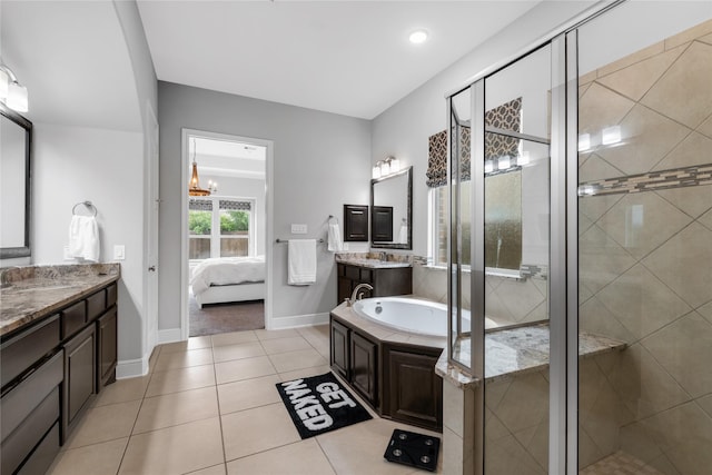 10610 Grace Hollow Dr, Cypress, TX 77433 - ensuite bathroom featuring baseboards, a bath, a shower stall, tile patterned floors, and two vanities