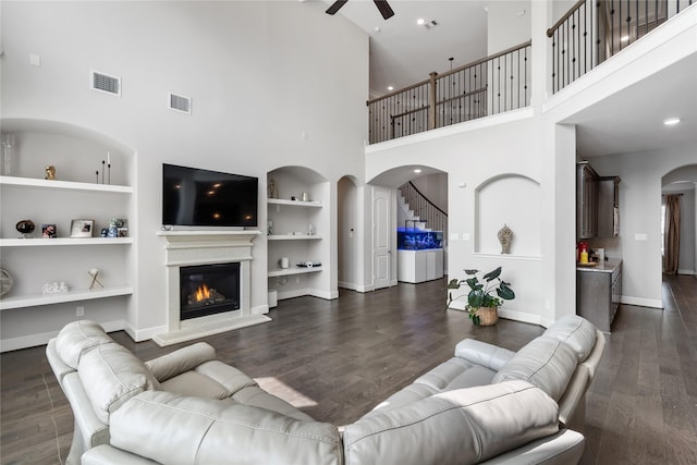 10610 Grace Hollow Dr, Cypress, TX 77433 - living room featuring arched walkways, baseboards, visible vents, and built in features