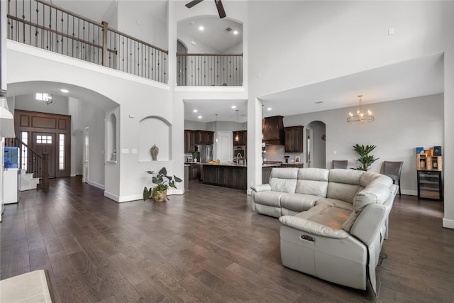 10610 Grace Hollow Dr, Cypress, TX 77433 - living room featuring arched walkways, beverage cooler, a high ceiling, and dark wood-type flooring
