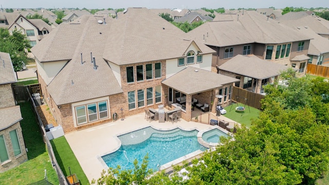 10610 Grace Hollow Dr, Cypress, TX 77433 - view of pool featuring outdoor lounge area, a pool with connected hot tub, a patio area, a residential view, and a fenced backyard