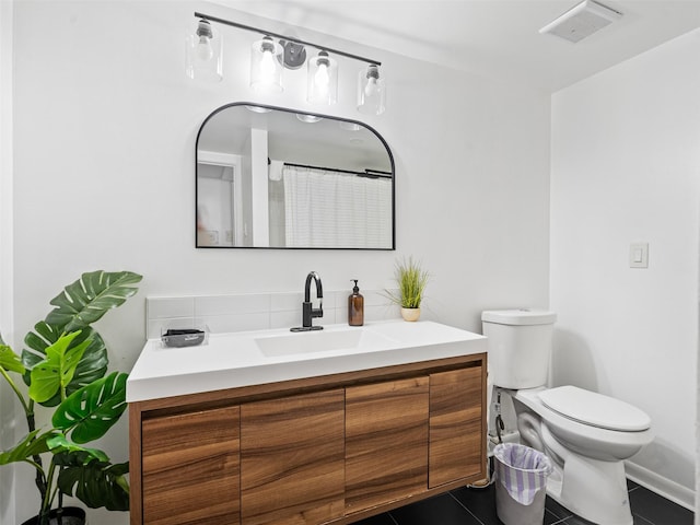 bathroom featuring toilet, tile patterned floors, vanity, and baseboards