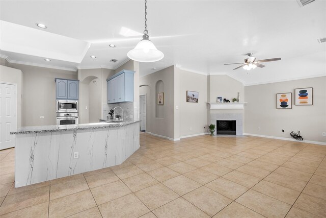 22022 Bridgestone Hawk Ct, Spring, TX 77388 - kitchen with crown molding, ceiling fan, appliances with stainless steel finishes, light tile patterned flooring, and blue cabinetry