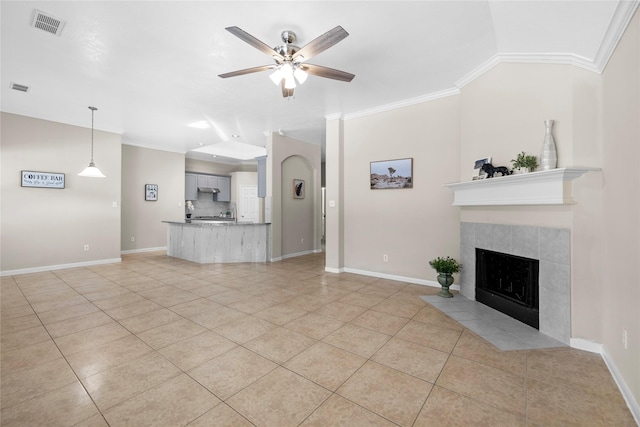 22022 Bridgestone Hawk Ct, Spring, TX 77388 - unfurnished living room featuring ornamental molding, visible vents, ceiling fan, light tile patterned floors, and a tile fireplace