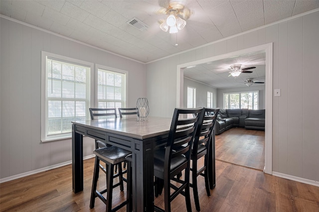 161281/2 Ridlon St, Channelview, TX 77530 - dining space featuring ceiling fan, crown molding, wood finished floors, a decorative wall, and baseboards