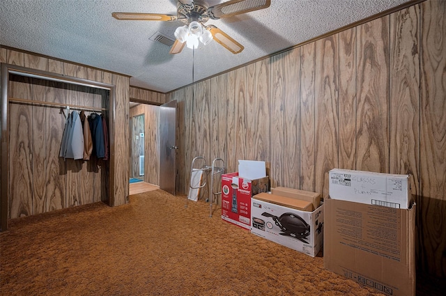161281/2 Ridlon St, Channelview, TX 77530 - carpeted bedroom with wood walls, a textured ceiling, a closet, and a ceiling fan