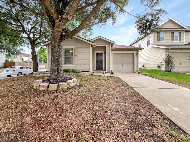 view of front of property featuring an attached garage, driveway, and fence