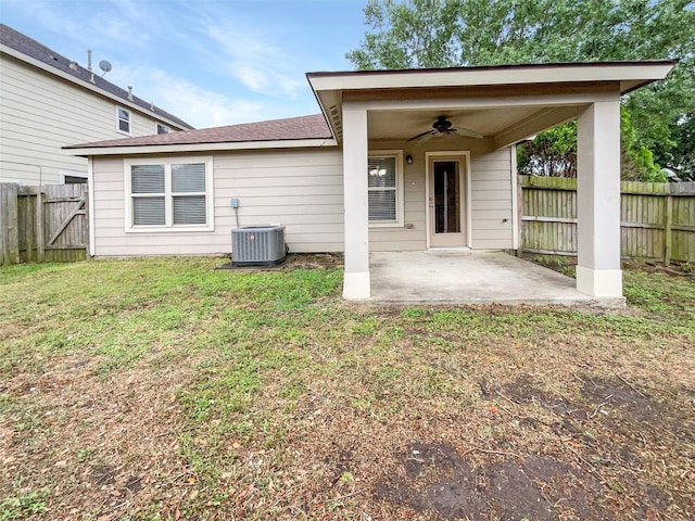 back of property with a ceiling fan, a patio area, a fenced backyard, and a lawn