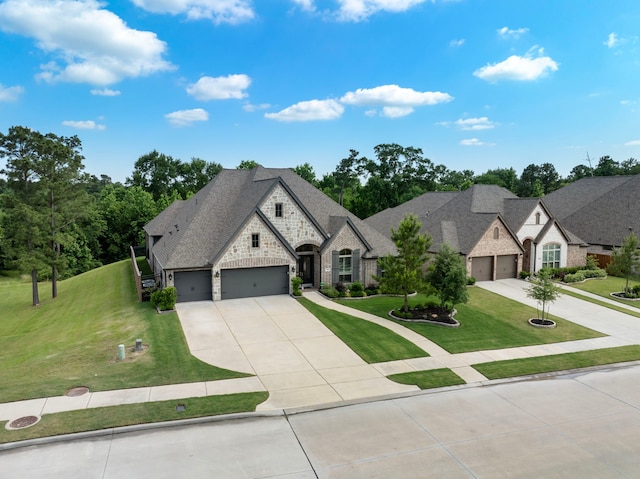 8642 Burdekin Rd, Magnolia, TX 77354 - french country inspired facade with driveway, a garage, stone siding, and a front yard