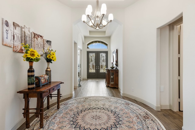 8642 Burdekin Rd, Magnolia, TX 77354 - foyer entrance with a chandelier, wood finished floors, baseboards, and arched walkways