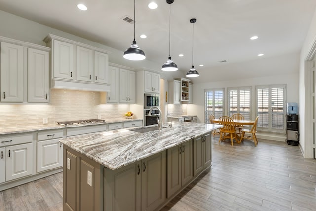 8642 Burdekin Rd, Magnolia, TX 77354 - kitchen featuring a sink, appliances with stainless steel finishes, white cabinetry, recessed lighting, and custom range hood