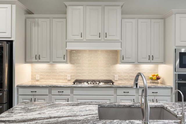 8642 Burdekin Rd, Magnolia, TX 77354 - kitchen featuring a sink, appliances with stainless steel finishes, white cabinets, and decorative backsplash