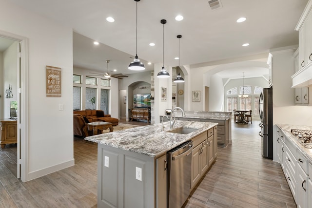 8642 Burdekin Rd, Magnolia, TX 77354 - kitchen with arched walkways, a center island with sink, stainless steel appliances, a sink, and recessed lighting