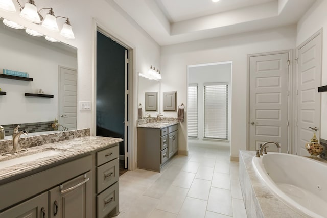 8642 Burdekin Rd, Magnolia, TX 77354 - full bath with a whirlpool tub, a tray ceiling, two vanities, and tile patterned floors