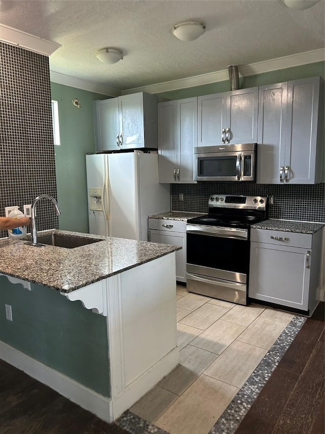 301 Rd 5232, Cleveland, TX 77327 - kitchen featuring stainless steel appliances, tasteful backsplash, dark stone countertops, and a sink