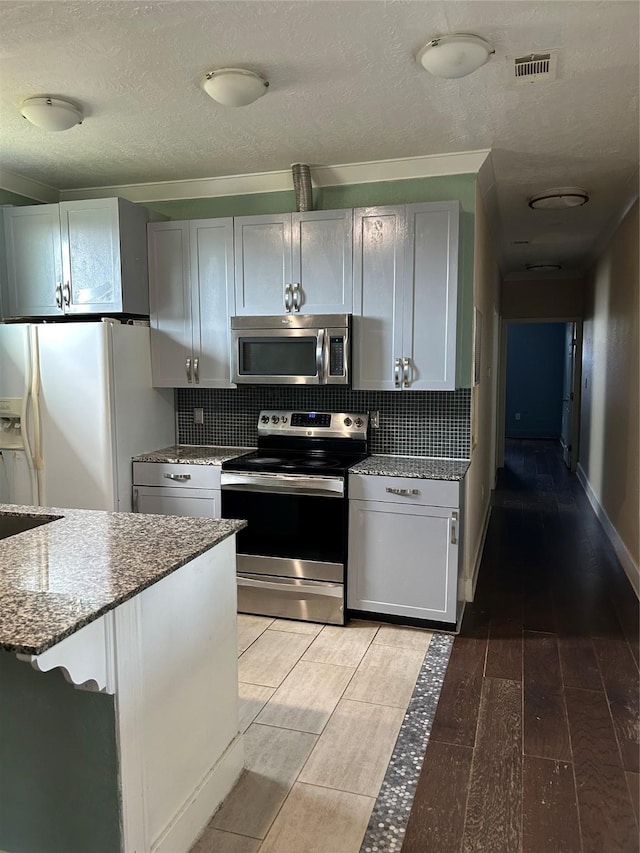 301 Rd 5232, Cleveland, TX 77327 - kitchen featuring backsplash, appliances with stainless steel finishes, light stone countertops, and light wood-type flooring