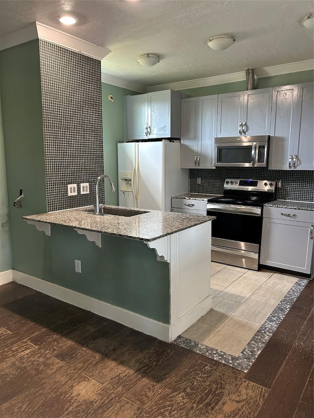 301 Rd 5232, Cleveland, TX 77327 - kitchen with light wood-type flooring, a kitchen bar, light stone counters, and appliances with stainless steel finishes