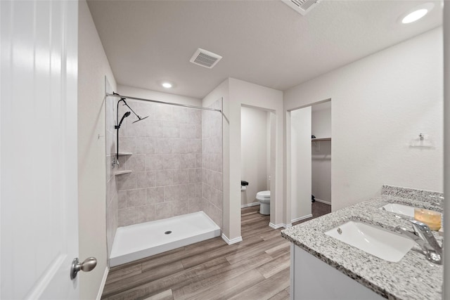 327 Pecos Dr, Huntsville, TX 77340 - bathroom featuring toilet, a shower stall, wood finished floors, a spacious closet, and double vanity
