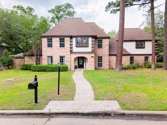 5502 Graystone Ln, Houston, TX 77069 - view of front of property with stucco siding, fence, a front lawn, a shingled roof, and brick siding